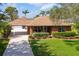 Charming single-story brick home with a well-manicured lawn and mature landscaping at 1688 Town Park Dr, Port Orange, FL 32129