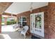 Charming front porch with a brick exterior and white wicker furniture at 1688 Town Park Dr, Port Orange, FL 32129