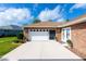 Attached garage with a brick exterior, white door and lush landscaping at 1688 Town Park Dr, Port Orange, FL 32129