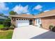 Attached garage with a brick exterior, white door and lush landscaping at 1688 Town Park Dr, Port Orange, FL 32129