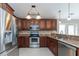 Modern kitchen with stainless steel appliances, dark wood cabinetry, and granite counters at 1688 Town Park Dr, Port Orange, FL 32129