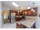 Open kitchen with stainless steel appliances, dark cabinets, and granite countertops at 1688 Town Park Dr, Port Orange, FL 32129