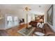 Comfortable living room featuring hardwood floors, ceiling fan, and access to the kitchen at 1688 Town Park Dr, Port Orange, FL 32129