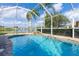 Screened-in pool with waterfall feature overlooking a tranquil lake at 1688 Town Park Dr, Port Orange, FL 32129