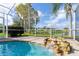 Close up view of a pool with waterfall in a screened enclosure at 1688 Town Park Dr, Port Orange, FL 32129