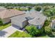 Aerial view of a well-maintained home with a manicured lawn, complemented by lush landscaping and a serene pond backdrop at 1748 Savannah Ln, Port Orange, FL 32128