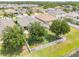 Aerial view of a well-kept backyard with lush green lawn and mature trees enclosed by a white picket fence at 1748 Savannah Ln, Port Orange, FL 32128