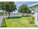 Backyard view featuring lush green grass, mature trees, and a pond view, ideal for outdoor enjoyment at 1748 Savannah Ln, Port Orange, FL 32128