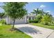 Landscaped front yard featuring mature tree, grass, and inviting curb appeal at 1748 Savannah Ln, Port Orange, FL 32128
