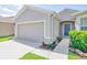 Close up of a single-story home with a two-car garage and beautifully landscaped walkway at 1748 Savannah Ln, Port Orange, FL 32128