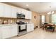 Eat-in kitchen featuring white cabinets, tile backsplash, and stainless steel appliances at 1748 Savannah Ln, Port Orange, FL 32128