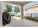 Covered outdoor patio with lush landscaping and grilling area for entertaining at 1748 Savannah Ln, Port Orange, FL 32128