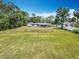Aerial view of the house, the large grassy backyard, fencing and mature trees at 1812 Bayview Dr, New Smyrna Beach, FL 32168