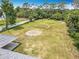 Aerial view of the property showcasing the lush green backyard, fencing, and mature trees at 1812 Bayview Dr, New Smyrna Beach, FL 32168