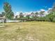 Large, grassy backyard that is partially fenced and bordered by mature trees at 1812 Bayview Dr, New Smyrna Beach, FL 32168