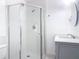 Bright bathroom featuring a tiled shower, gray vanity with modern fixtures, and tile flooring at 1812 Bayview Dr, New Smyrna Beach, FL 32168