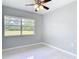 Bedroom showcasing tile flooring, a ceiling fan, and a bright, green view at 1812 Bayview Dr, New Smyrna Beach, FL 32168