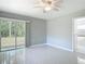 This bedroom has tile floors, a ceiling fan, glass sliding doors to the backyard and an attached bathroom at 1812 Bayview Dr, New Smyrna Beach, FL 32168