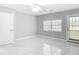 Simple bedroom with tile flooring, ceiling fan, window, and door to exterior at 1812 Bayview Dr, New Smyrna Beach, FL 32168