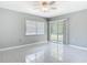 This bedroom has tile floors, a ceiling fan, and glass sliding doors to the backyard at 1812 Bayview Dr, New Smyrna Beach, FL 32168