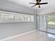 Bedroom with large window, tile flooring, and sliding glass door to exterior at 1812 Bayview Dr, New Smyrna Beach, FL 32168
