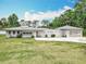 Charming single-story home with white brick exterior, decorative concrete privacy panels, and a well-manicured lawn at 1812 Bayview Dr, New Smyrna Beach, FL 32168