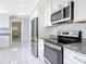Modern kitchen featuring stainless steel appliances and white cabinets with tile flooring at 1812 Bayview Dr, New Smyrna Beach, FL 32168