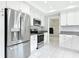 Well-lit kitchen with stainless steel appliances, white cabinets, and tile flooring at 1812 Bayview Dr, New Smyrna Beach, FL 32168