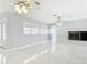 Bright living room featuring tile flooring, modern ceiling fans, and a decorative brick fireplace at 1812 Bayview Dr, New Smyrna Beach, FL 32168