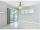 Bright living room with tiled floors, sliding glass doors, and a ceiling fan at 1812 Bayview Dr, New Smyrna Beach, FL 32168