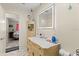 Bathroom with lighted mirror and decorative cabinet, adjacent to bedroom at 1851 Needle Palm Dr, Edgewater, FL 32141