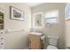 Neutral bathroom featuring illuminated mirror, window, and wood-style vanity at 1851 Needle Palm Dr, Edgewater, FL 32141
