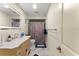 Bathroom with illuminated mirror, patterned shower curtain, and a blue accent rug at 1851 Needle Palm Dr, Edgewater, FL 32141