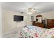 Bright bedroom features a ceiling fan, TV, dresser, and floral bedding at 1851 Needle Palm Dr, Edgewater, FL 32141