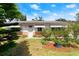 Inviting single-story home with lush landscaping and a well-manicured front lawn at 1851 Needle Palm Dr, Edgewater, FL 32141