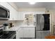 Modern kitchen boasts stainless steel appliances, white cabinetry, and a convenient breakfast bar area at 1851 Needle Palm Dr, Edgewater, FL 32141