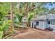 Relaxing backyard with a hammock under mature trees and a charming detached structure at 209 Esther St, New Smyrna Beach, FL 32169