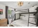 Modern bedroom with a bunk bed, wood-look flooring, and natural light from the window at 209 Esther St, New Smyrna Beach, FL 32169