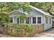 Charming home featuring blue siding, a mature tree, and a privacy fence at 209 Esther St, New Smyrna Beach, FL 32169