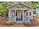 Charming one-story home with a cozy front porch, complemented by a wooden fish decoration and inviting seating area at 209 Esther St, New Smyrna Beach, FL 32169
