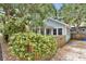 View of the charming one-story home with light gray facade, complemented by a wood fence, offering a cozy and inviting feel at 209 Esther St, New Smyrna Beach, FL 32169