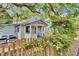Charming home featuring a picket fence and a small porch, set under the shade of mature trees at 209 Esther St, New Smyrna Beach, FL 32169