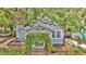 Inviting cottage-style home with lush greenery over the entry and a cozy porch area at 209 Esther St, New Smyrna Beach, FL 32169