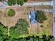A bird's eye view of the property features a well-kept lot, mature trees, and a tranquil neighborhood setting at 242 Cypress Ave, Oak Hill, FL 32759