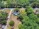 An aerial view of a property with mature trees, offering a sense of privacy within the neighborhood at 242 Cypress Ave, Oak Hill, FL 32759