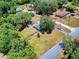Aerial view of the property showcasing its well-maintained lawn, mature trees, utility shed, and proximity to neighborhood streets at 242 Cypress Ave, Oak Hill, FL 32759
