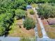 This aerial view captures the home’s location within a neighborhood with mature trees and a convenient driveway at 242 Cypress Ave, Oak Hill, FL 32759