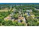 Aerial view showcasing a neighborhood with tree-lined streets, homes, and a mix of residential and green spaces at 242 Cypress Ave, Oak Hill, FL 32759