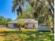 Backyard featuring a screened porch, a shed, a ladder, and trees in a shady lawn at 242 Cypress Ave, Oak Hill, FL 32759