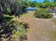Spacious backyard with green grass and mature trees offering ample shade and privacy at 242 Cypress Ave, Oak Hill, FL 32759